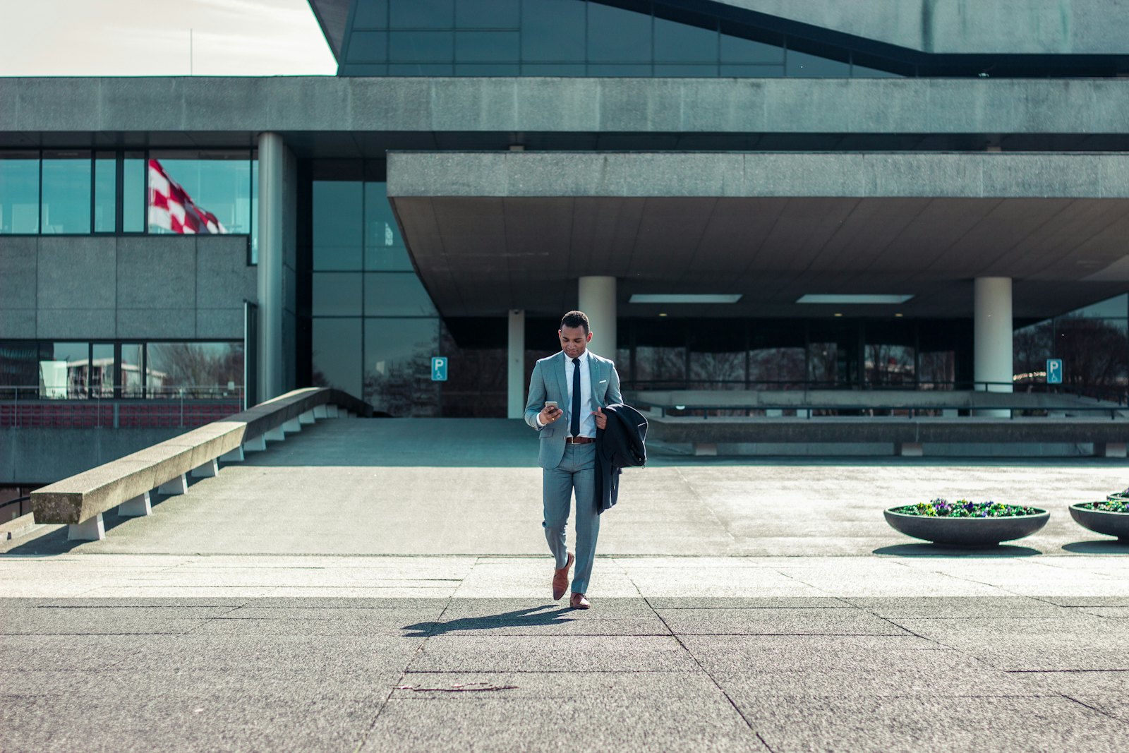 A business traveller in a coat walking through a modern city street