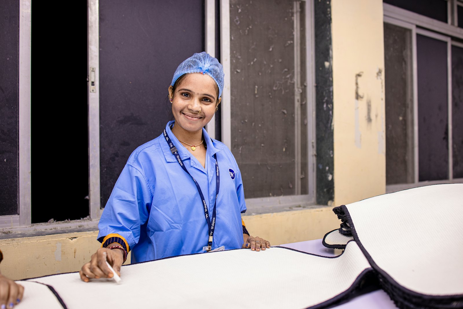 A smiling healthcare worker in scrubs and a surgical cap